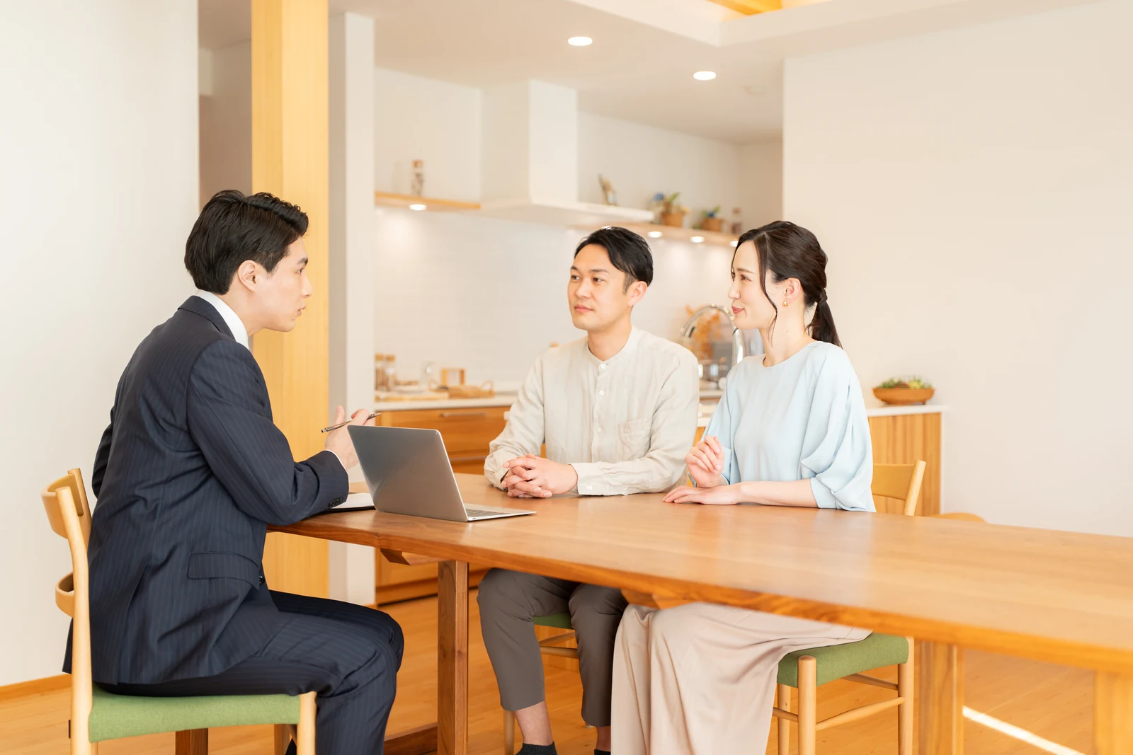 木のテーブルで住まいについて相談する様子